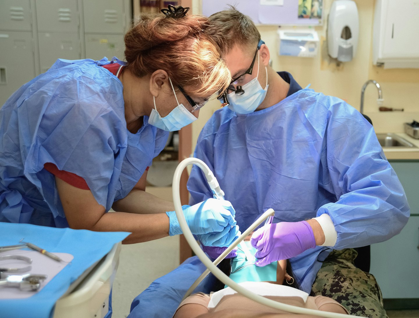 Dental professionals practice procedure on manikin in clinic.