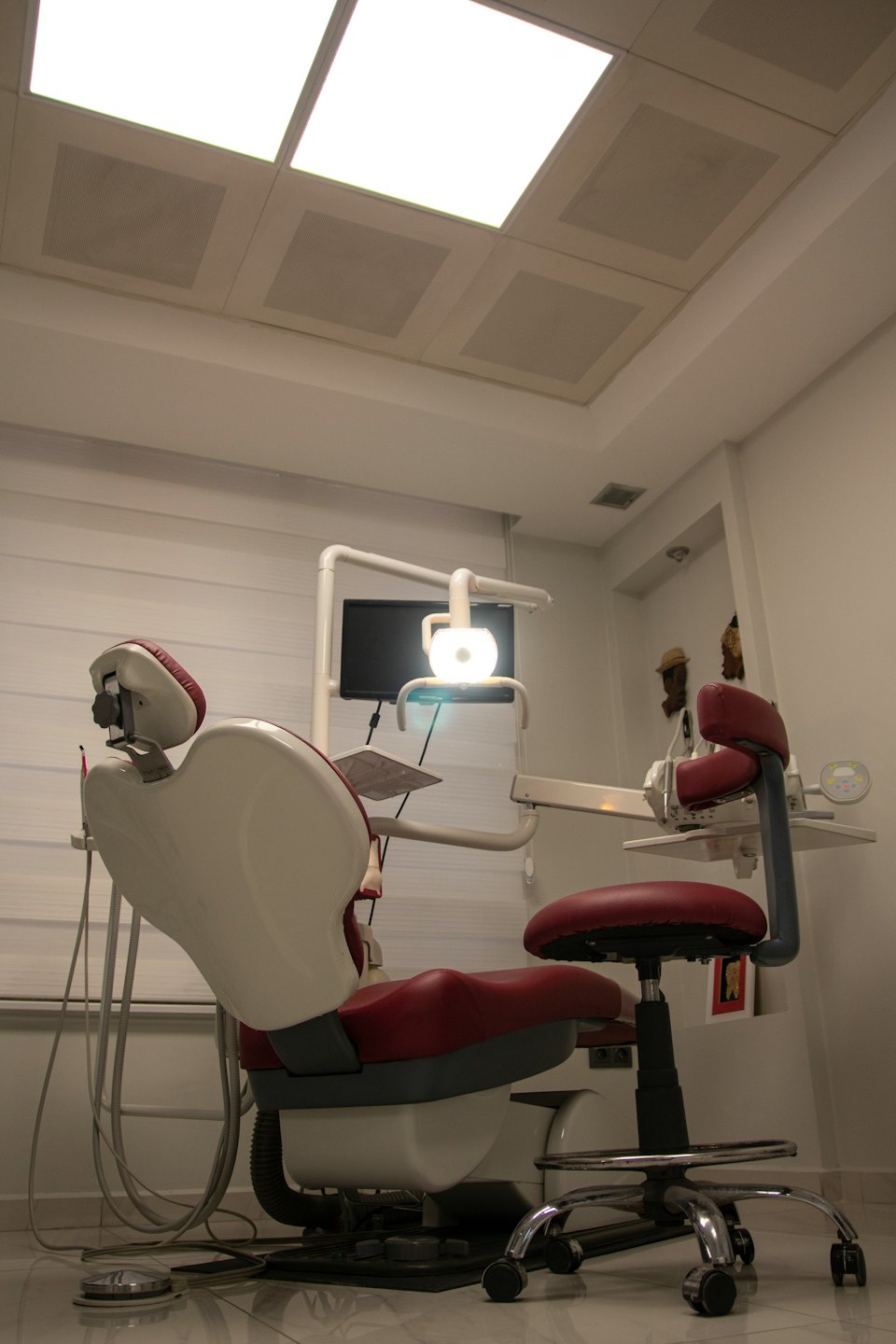 A modern dentist chair with equipment in an examination room.