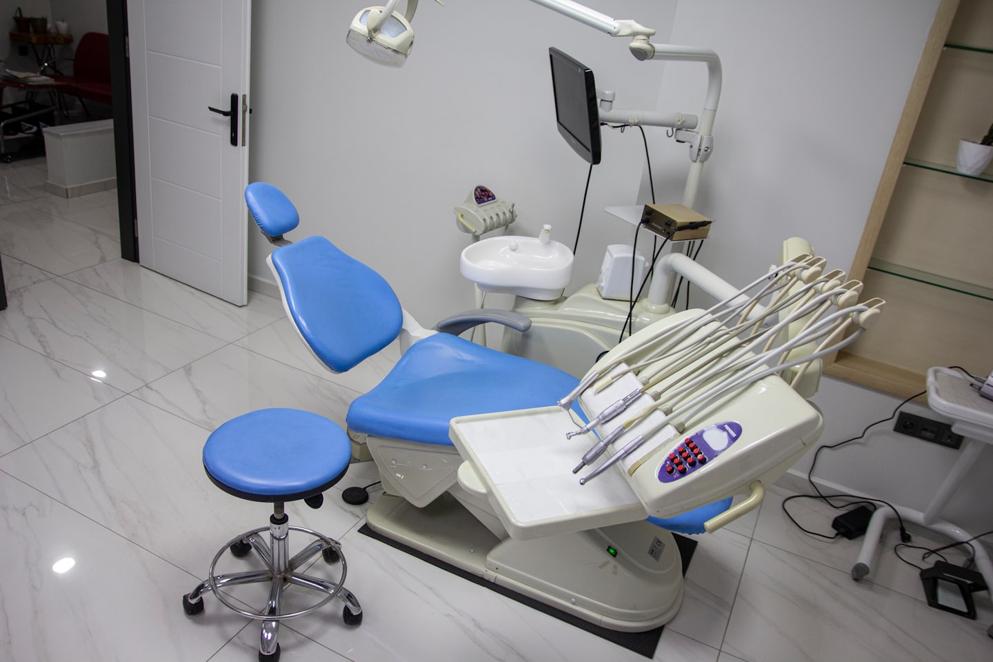 Empty dental operatory with blue chair and equipment.